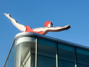Señalización sobre edificio con forma de mujer nadadora